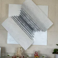 A closer view of the "Flight of Knowledge" installation. It sits above a small altar, adding to the spiritual and contemplative nature of the space.