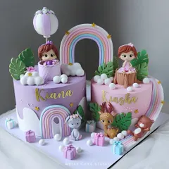 Twin cakes for twin girls. This beautiful set features two complementary cakes in pink and purple, each with its own unique details but a shared theme.