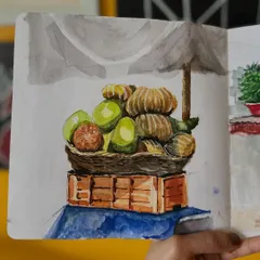 A slightly different perspective of the fruit basket, showing the sketch within my open sketchbook. This view gives a sense of the environment and the process of urban sketching on the go.