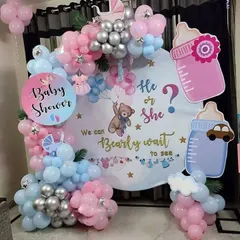 A detailed look at the "Bearly Wait" baby shower theme, perfect for a home setting. The round backdrop is surrounded by pink, blue, and silver balloons, with cute baby-themed cutouts.