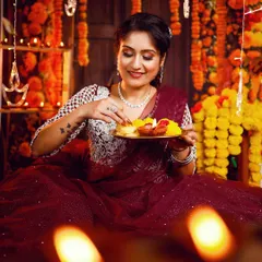 A perfect look for a Diwali night celebration. This image from a festive photoshoot captures a warm, glamorous makeup style with defined eyes and glowing skin, set against a beautiful backdrop of diyas and marigolds.