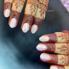 A beautiful pearl chrome and glitter nail set that perfectly complements this bride's intricate henna design.