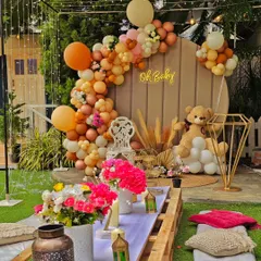 A cozy "Oh Baby" shower with a bohemian picnic setup. The neutral-toned balloon arch and teddy bear prop create a warm and inviting atmosphere for celebrating the mom-to-be.