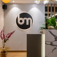 The reception at the Brandman office, where a backlit logo and a marble-clad desk make a definitive brand statement. We craft welcome areas that embody character and calm from the moment you step inside.