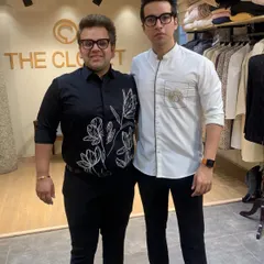 My brother Nikhil and I, the founders of The Closet. We are wearing two of our custom shirt designs, a black floral embroidered shirt and a white asymmetrical zip shirt, showcasing our unique approach to smart casual wear.