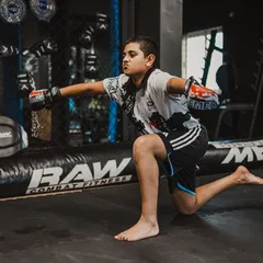 A young fighter practices his striking form, demonstrating the focus and dedication we instill in our youth program.