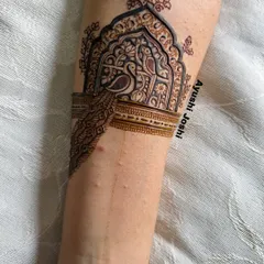 A close-up of the arm band for a baby shower mehendi, featuring a peacock in a jharokha, symbolizing beauty and grace for the mom-to-be.