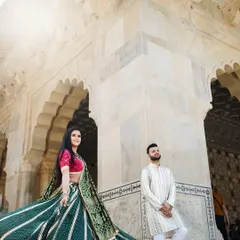 A dynamic low-angle shot of a couple in a Jaipur palace, with the bride's swirling lehenga adding movement and energy to the grand architectural setting.