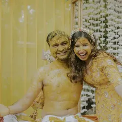A candid moment of pure happiness. After being covered in turmeric paste, the couple shares a joyful, messy hug, showcasing the fun and intimacy of the Haldi ceremony.