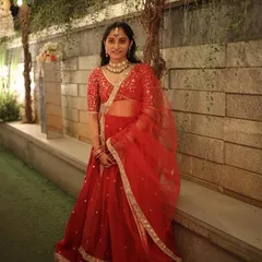 A full-length view of our client in the red lehenga. The outfit creates a beautiful silhouette, and the color is perfect for making a statement at a wedding celebration.