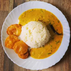 My all-time favorite comfort meal, Kadhi Chawal. A perfect mound of steamed rice is served with a tangy yogurt-based curry and crispy potato fritters (Aloo Pakora).