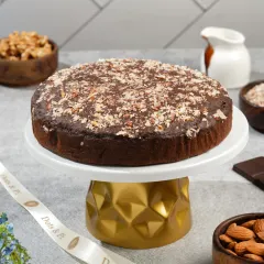 A simple yet elegant shot of a chocolate walnut cake on a modern cake stand. This clean, bright style is perfect for a home baker's website or Instagram profile.