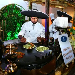 We believe food should be an experience. Here, our chef prepares fresh vegetarian quesadillas at a live Mexican station, complete with a sombrero for a fun, authentic touch.