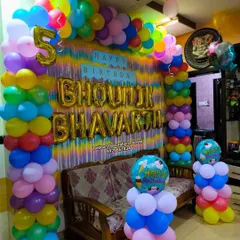 A vibrant and colorful birthday decoration using a multitude of colors. The balloon arch and pillars create a joyful and festive atmosphere, perfect for a fun-filled celebration.