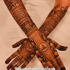This design incorporates Lord Ganesha on the palm for blessings and auspicious beginnings. The rest of the arm is filled with floral patterns and the couple's initials.