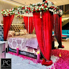 Another angle of the romantic room setup, showing the beautiful details of the floral canopy and hanging crystal strings. The warm glow of candles adds to the intimate atmosphere.