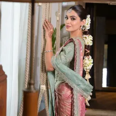 This shot highlights how the floral braid complements the overall bridal ensemble. The sleek front and elaborate back create a balanced look perfect for traditional photoshoots.