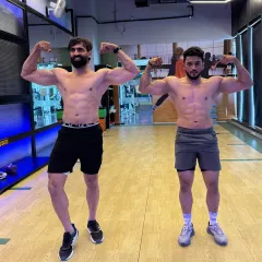 Sweat together, shine together. Posing with a training partner, both of us showcasing the physiques we've built through hard work and mutual motivation.