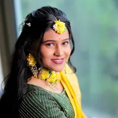 A happy bride ready for her Haldi ceremony. The makeup is light and glowy, with a bright lip color to match the festive mood.