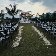 The wedding aisle is kept simple and beautiful with scattered white rose petals and candles. This minimalist approach ensures the focus remains on the couple and the ceremony itself.