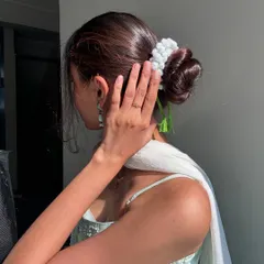 An elegant side profile showing the handmade crochet gajra nestled in a sleek hair bun. It's the perfect accessory for weddings, festivals, or any special occasion.