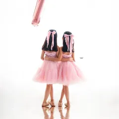 Turning seven with your best friend by your side. This creative shot captures these twin sisters on their birthday, with a single balloon marking their special age.