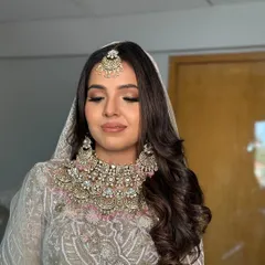 A soft glam look for a wedding ceremony or reception. I created deep, flowing waves and set them to one side for a romantic and ethereal feel that complements her pastel outfit.