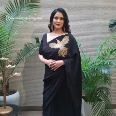 A full-length shot showcasing the complete look. The makeup perfectly complements the elegant black saree, creating a cohesive and head-turning ensemble.
