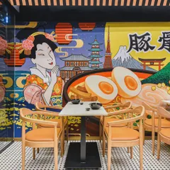 This Japanese restaurant design blends two distinct styles. One side features vibrant, graphic murals depicting iconic Japanese culture for a high-energy feel, while the other offers a calm, minimalist aesthetic for a more intimate dining experience.