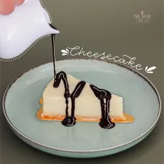 Another look at our classic cheesecake, this time generously topped with a decadent chocolate sauce. You can customize your slice to make it your own.