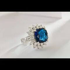 A classic product-on-white shot of a blue sapphire and diamond halo ring. This type of clean, distraction-free image is fundamental for e-commerce listings, allowing customers to examine the piece from every angle with complete clarity.