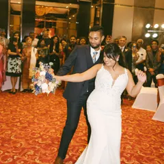 The bride and groom making their joyful entrance at the reception. Her soft glam makeup and beautiful white dress make her look like a dream.