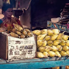 A street vendor sells roasted and fresh corn from her cart in Hampi. This photo captures the textures and colors of a typical market scene, showing a slice of everyday life and local culture.