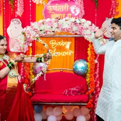 A fun and playful moment from a traditional baby shower. The mom-to-be playfully aims a bow and arrow at her partner, surrounded by festive decorations.