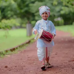 Marching to the beat of his own dhol. This portrait captures the playful spirit of a child dressed in a traditional dhoti and turban for a cultural themed photoshoot. The path in the park provided a perfect natural backdrop.
