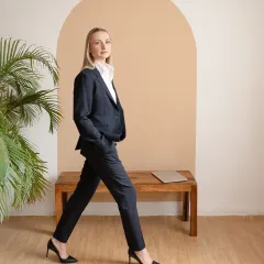 A professional portrait for a business leader, set in a minimalist studio. The focus is on conveying confidence and approachability through clean lines, natural posture, and direct engagement.