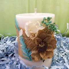 Handcrafted elegance in every detail. This rustic floral pillar candle is wrapped in burlap and decorated with dried flowers, bringing warmth, charm, and a touch of nature to your space.