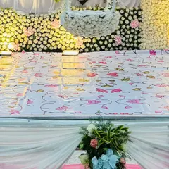 This image highlights a hanging cradle, or 'thottil', completely covered in white flowers. It is set against a dense flower wall, creating a dreamy and ethereal look for a naming ceremony.