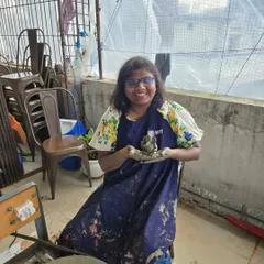 A participant proudly holds up the small Ganesha idol she has sculpted from clay. Our hand-building sessions allow for incredible creativity and personal expression.