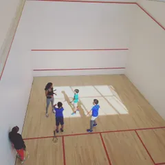 A high-angle view of one of our coaches working with our youngest group of players. We make learning the basics of squash engaging and accessible for all age groups.
