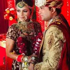 A candid moment between the bride and groom. Her intricate bridal lehenga and green stone jewellery set are both part of my rental collection, allowing you to get a complete designer look.