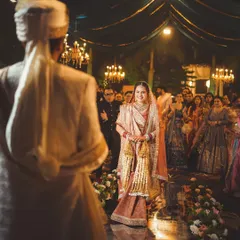 The bride's walk down the aisle is one of the most emotional moments. This over-the-shoulder shot from the groom's perspective captures his first look at his bride, with all the anticipation and love in her eyes.