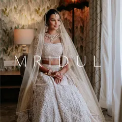 A full-length portrait of a bride in her stunning white lehenga. The soft natural light and her elegant pose create a picture of pure grace and beauty.