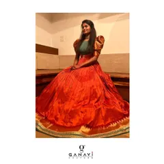 This magnificent gown was created by transforming the client's mother's old saree into a new heirloom. The rich orange silk was repurposed into a voluminous, floor-length skirt, paired with a modern puff-sleeve blouse, preserving memories in a contemporary form.