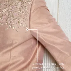 The refined blush pink of this raw silk fabric is enhanced by delicate zari embroidery. The soft sheen and intricate detailing make it perfect for festive or wedding wear.