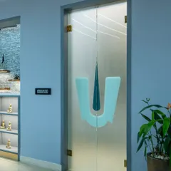 A custom frosted glass door with a 'Thirunamam' symbol, creating a respectful and beautiful separation for the pooja space.
