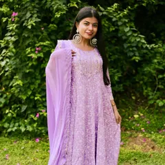 An outdoor lifestyle shoot allows us to play with natural light and vibrant colors. The soft lavender of the suit pops against the green foliage, and the large traditional earrings add a perfect statement piece to the look.