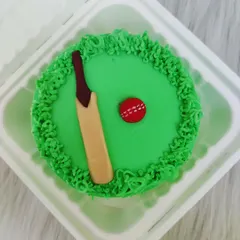 A mini cricket-themed bento cake. Even on a small cake, I can create a fun design with a fondant bat and ball on a field of green buttercream.