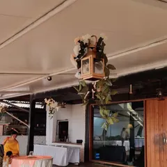 Detail is key. For this event, we hung wooden lanterns adorned with flowers and greenery from the ceiling, adding a touch of rustic elegance to the guest area.