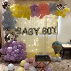 This "BABY BOY" home decoration uses a curtain of fairy lights as a backdrop for the foil balloons. The pastel balloon frame adds color and softness, creating a lovely photo spot.